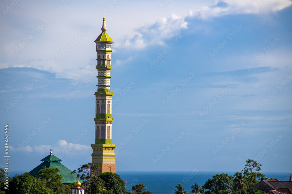 The mosque's domed minaret against the background of blue clouds