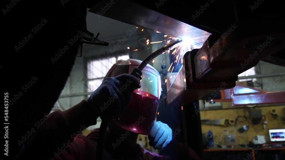 the welder performs welding works of metal structures for custom cars the welder performs welding works of metal structures for custom cars