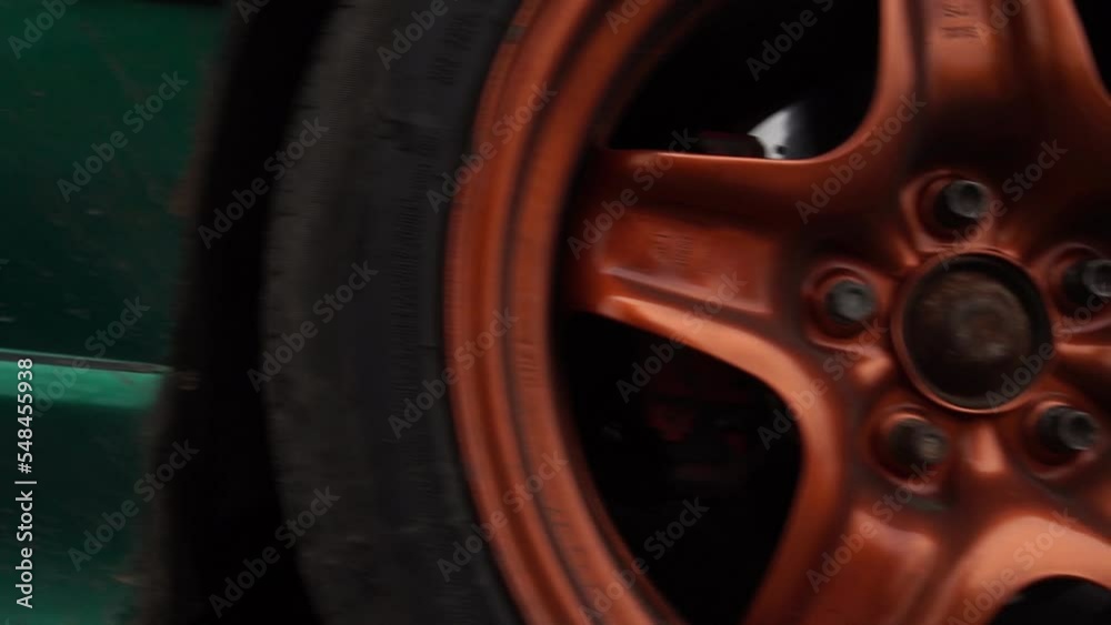tuned green car on metallic burnt orange rims dirty in autumn tuned green car on metallic burnt orange rims dirty in autumn