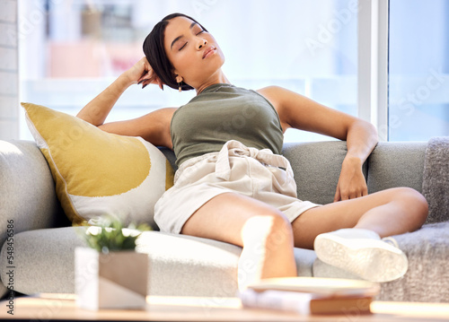 Tired, woman relax and rest on sofa of living room alone in house,afternoon nap and eyes closed on couch at home. Woman sleeping, calm wellness break and relaxing in apartment with peace freedom