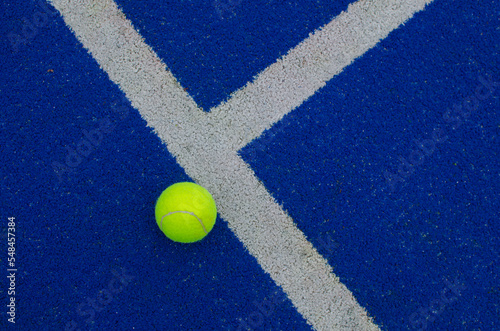 ball next to the line on a blue paddle tennis court © Vic