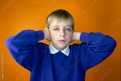 portrait of a person, a young boy covering his ears, concept, not interested