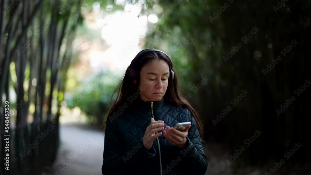 Portrait of a pretty woman on a walk in the park listening to music on the phone Portrait of a pretty woman on a walk in the park listening to music on the phone