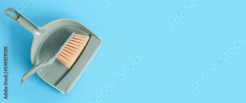 Dustpan and brush on light blue background with space for text, top view