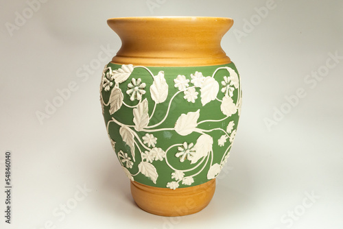 ceramic vase with floral carvings on a white background
