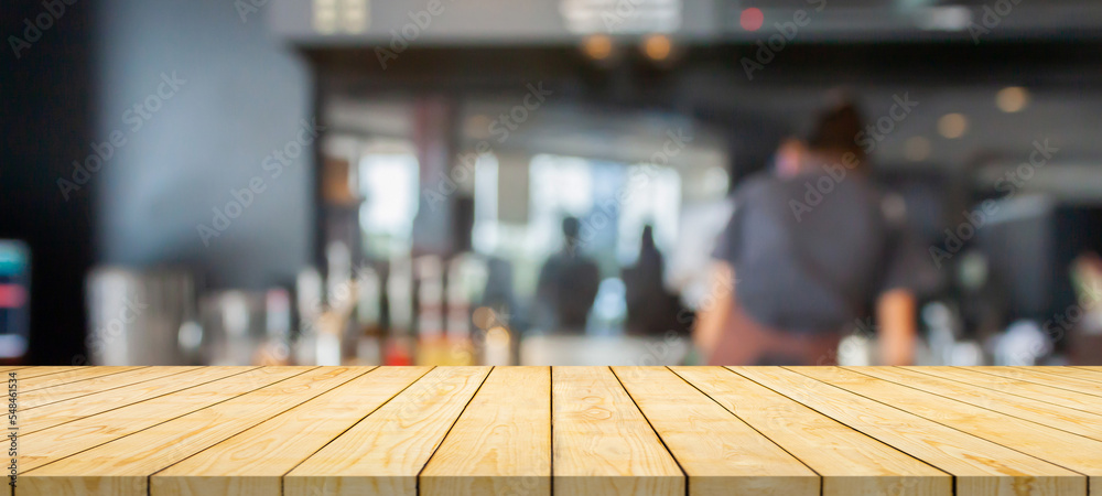 Empty wood table top with coffee shop cafe restaurant counter blur background Empty wood table top with coffee shop cafe restaurant counter blur background