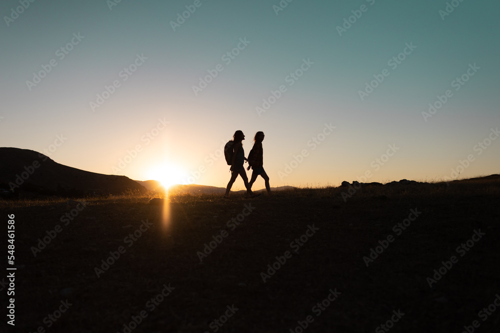 Fototapeta premium two people walk along a mountain range