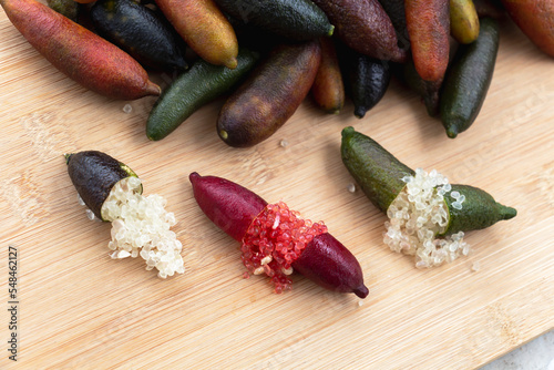 Finger lime or caviar lime of Australian cut in half, it is edible fruits used for cooking gourmet cuisine. Fresh Citrus australasica on wood background.