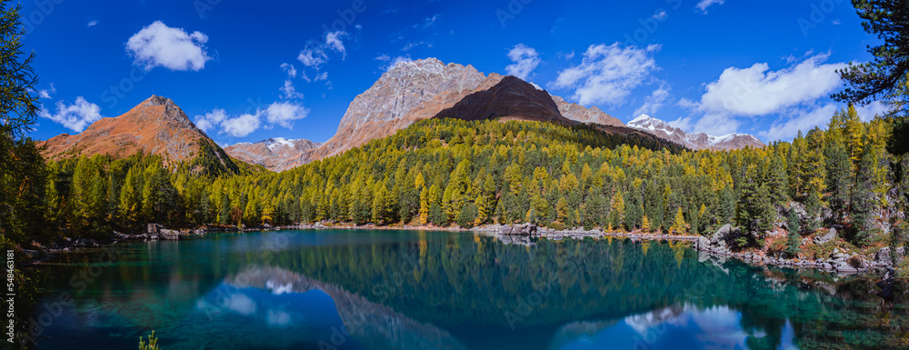 The saoseo lake with its spectacular colors and the swiss alps with the autumn light, near the village of Poschiavo, Switzerland - October 2022.