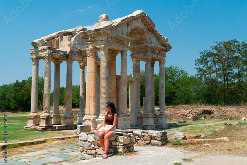 Young tourist sitting in front of the ruins of the temple of aphrodisia in turkey photo
