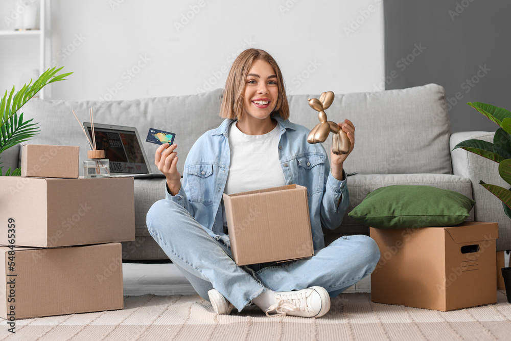 Young woman with credit card and new parcel at home. Online shopping Young woman with credit card and new parcel at home. Online shopping