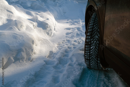 Closeup of car wheel on a snowy road at winter. Dangerous driving conditions. © CrispyMedia