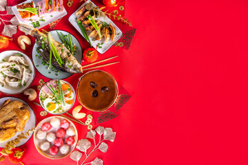 Traditional Chinese lunar New Year dinner table, party invitation, menu background with pork, fried fish, chicken, rice balls, dumplings, fortune cookie, nian gao cake, noodles, chinese decorations