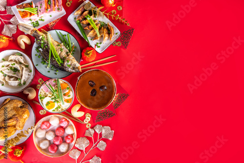 Traditional Chinese lunar New Year dinner table  party invitation  menu background with pork  fried fish  chicken  rice balls  dumplings  fortune cookie  nian gao cake  noodles  chinese decorations