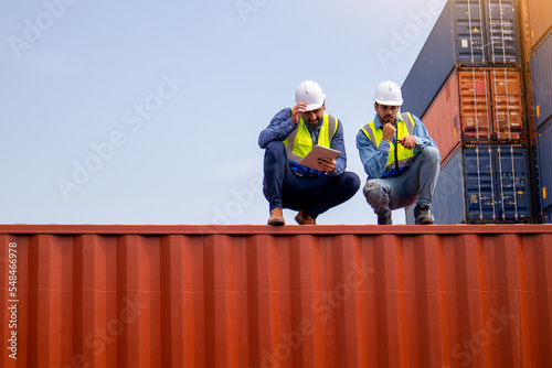 Team Businessman checking goods at a container shipping company, Caucasian worker planning transportation of goods to distributors through the ship. The concept of logistics worldwide cargo container