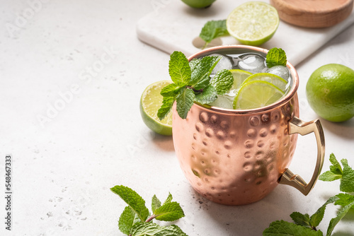 Moscow mule alcoholic cocktail in copper mug with lime, mint and cucumber