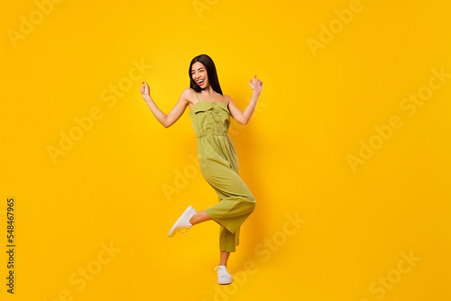 Full body photo of overjoyed positive thai person enjoy dancing clubbing isolated on yellow color background