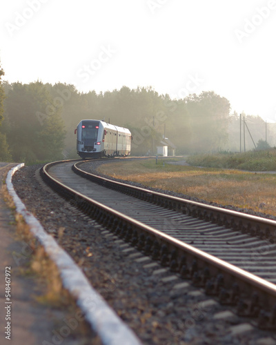 Train leaving the station on foggy morning. Industrial landscape