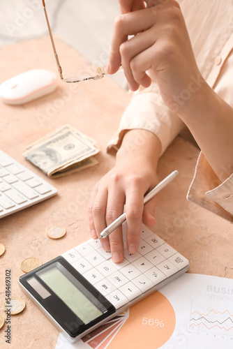 Woman with pen using calcul...