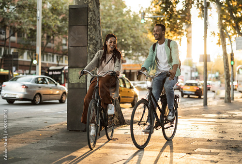 Wallpaper Mural African american couple cycling in the city. Students laughing. Torontodigital.ca