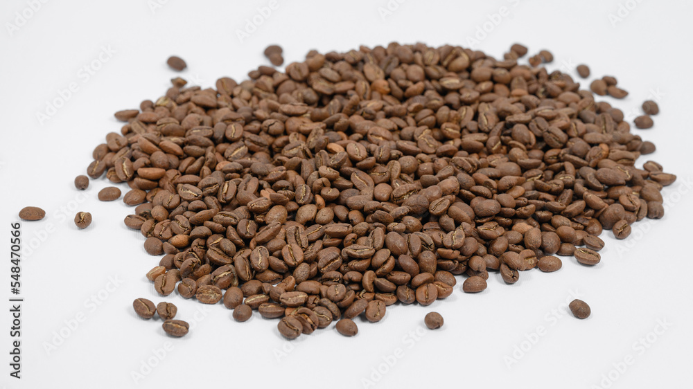 Fragrant and roasted coffee beans on a white background, place for inscription and advertising. Fragrant and roasted coffee beans on a white background, place for inscription and advertising.