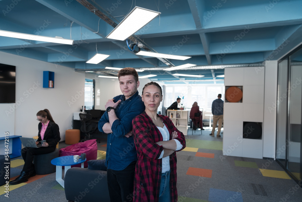 Fototapeta premium Portrait of a successful creative businessman and businesswoman looking at camera and smiling. Diverse business people standing together at startup.