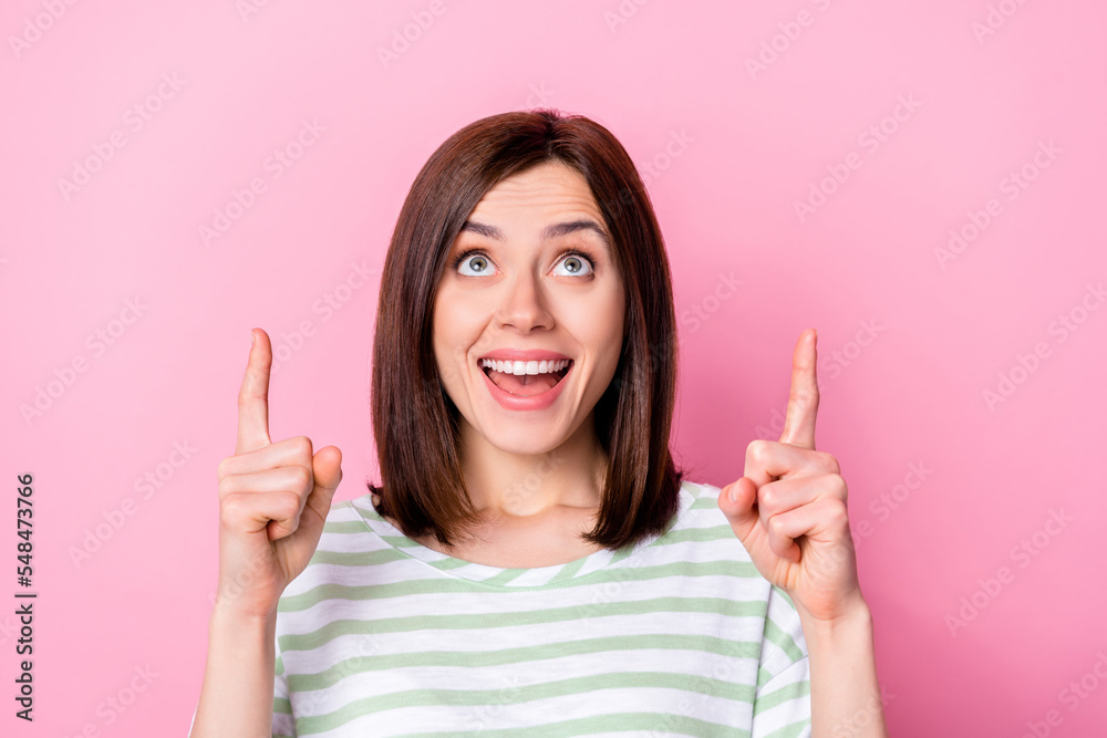 Portrait of positive cheerful girl with bob hairdo wear striped t-shirt directing look empty space sale isolated on pink color background Portrait of positive cheerful girl with bob hairdo wear striped t-shirt directing look empty space sale isolated on pink color background
