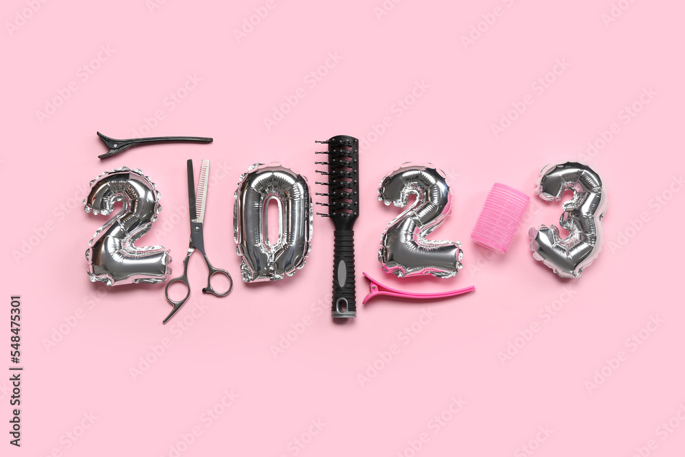Figure 2023 made of balloons and hairdresser's tools on pink background Figure 2023 made of balloons and hairdresser's tools on pink background