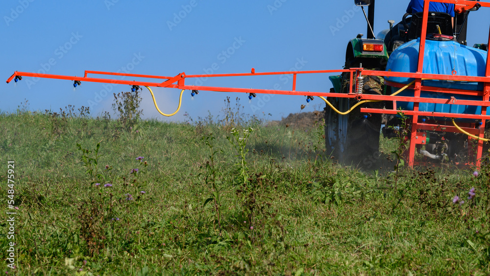 A tractor with a tank and attached equipment for spraying the field from pests and weeds, the process of processing the field. A tractor with a tank and attached equipment for spraying the field from pests and weeds, the process of processing the field.