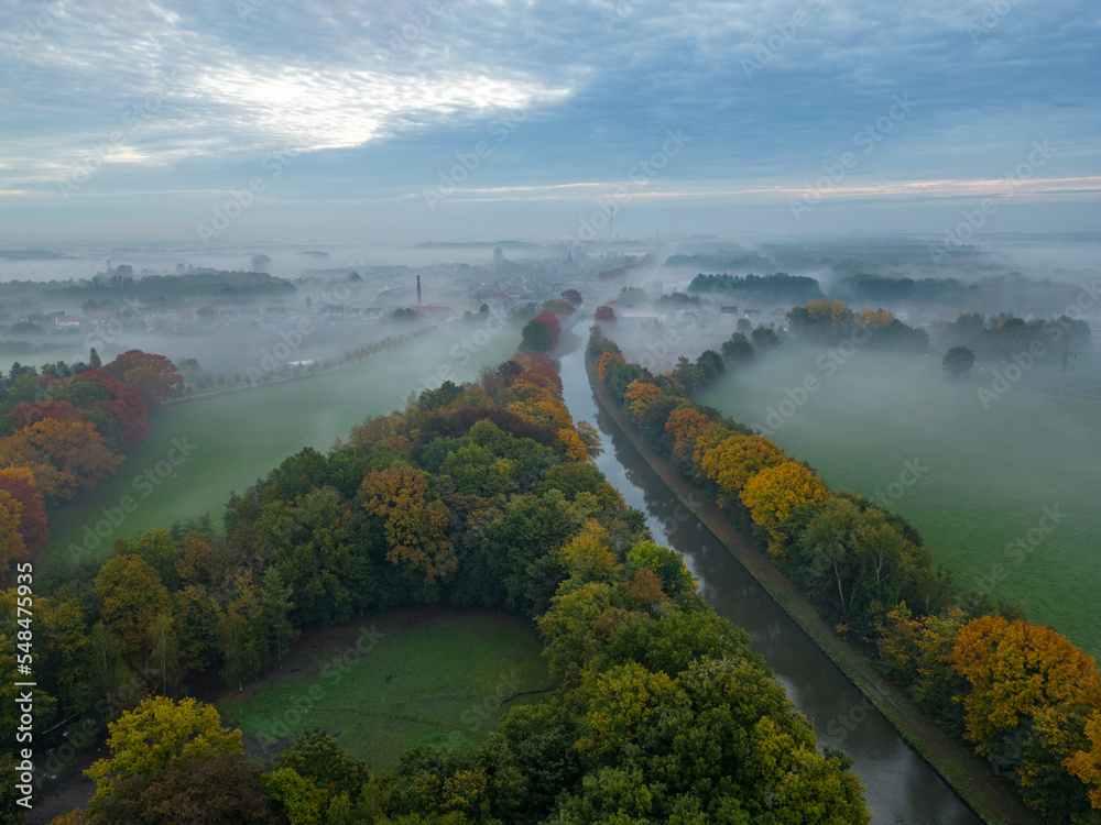 Aerial view of a rural landscape during sunrise in Belgium. Rural farm, corn fields, green fields and colorful fall foliage on the trees, sunlight and fog. Belgium, Europe. High quality photo Aerial view of a rural landscape during sunrise in Belgium. Rural farm, corn fields, green fields and colorful fall foliage on the trees, sunlight and fog. Belgium, Europe. High quality photo