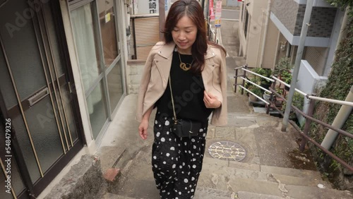 Middle aged asian woman walking old stone steps in Nagasaki Japan.