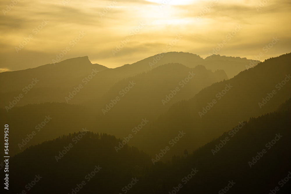 Spectacular view of mountain ranges silhouettes with yellow sunlight. Sunset in Allgau, Germany, Alps.