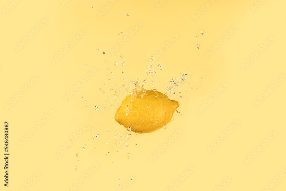 Fresh lemon on yellow background with water splash Fresh lemon on yellow background with water splash
