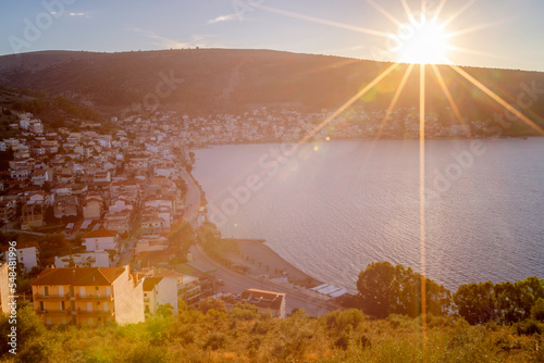 Panoramic view of Amfilochia town during early sunset with star-shaped sun and warm atmosphere. Amfilochia is a small rural town in western Greece, in the region of Etoloakarnania.  photo