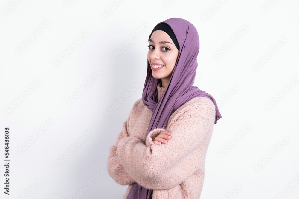 muslim woman wearing hijab and knitted sweater over white background cross hands look copy space