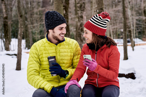 Cheerful couple taking break in winter park