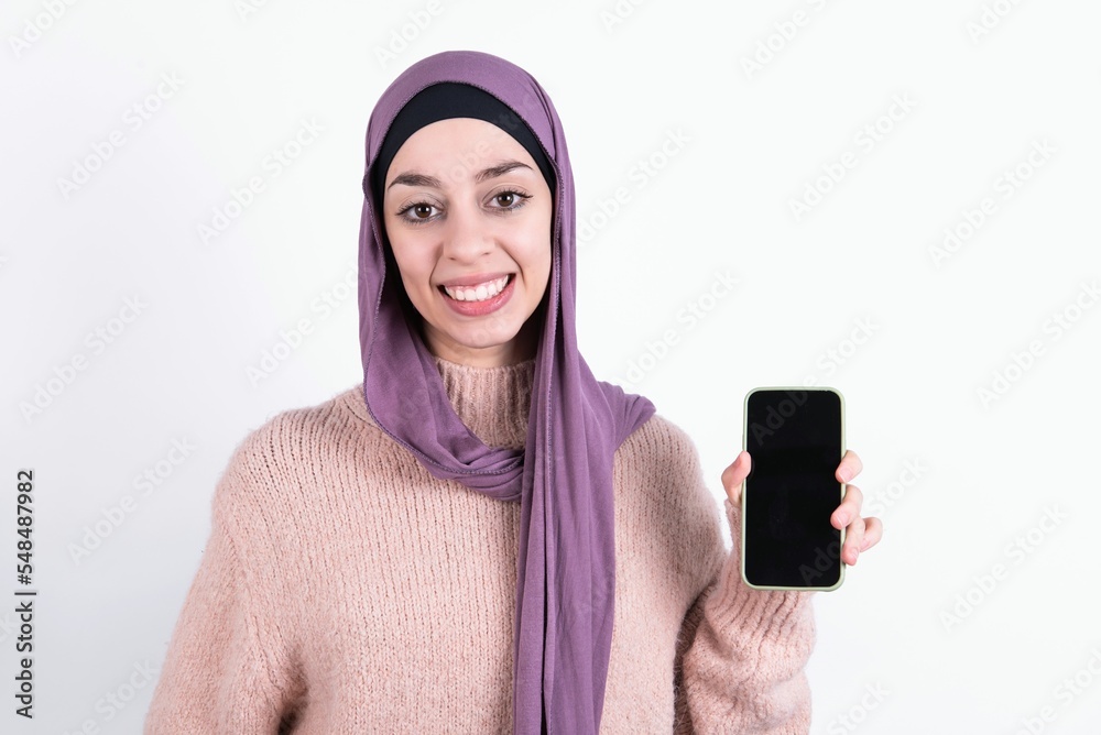 Εκτύπωση καμβά Smiling beautiful muslim woman wearing hijab and warm jumper over white background Mock up copy space