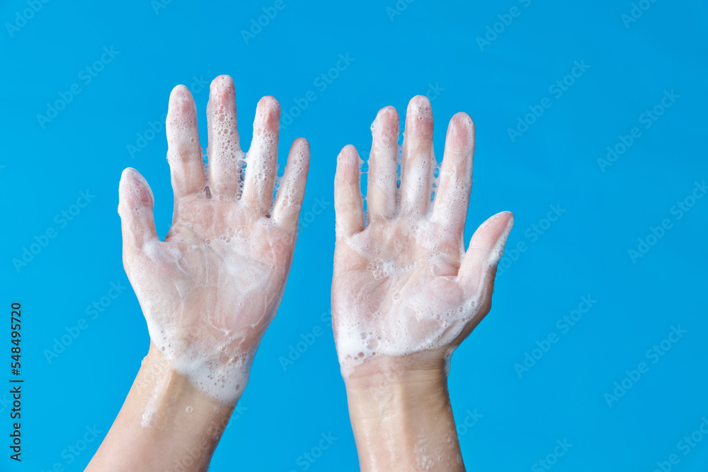 Woman washing hands on blue background Woman washing hands on blue background