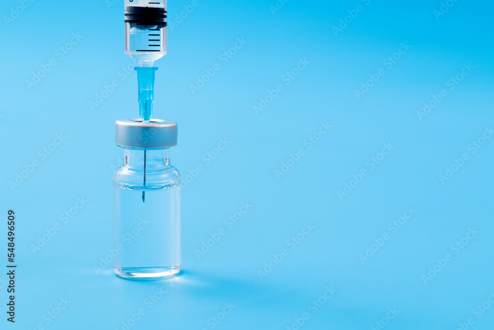 Syringe insertion ampoule on blue background Syringe insertion ampoule on blue background