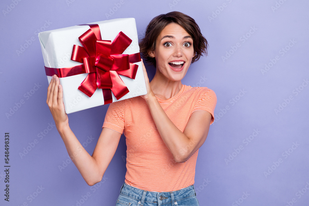 Photo of overjoyed impressed lady trendy striped clothes hand hold gift valentine party isolated on purple color background Photo of overjoyed impressed lady trendy striped clothes hand hold gift valentine party isolated on purple color background