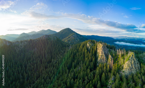 Peak of Rhodope mountain with forests against background of clouds. Panorama, top view