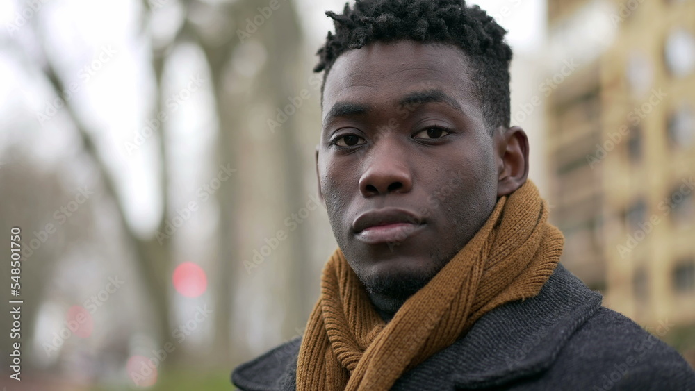 Young black man standing outside wearing coat and scarf looking at camera  portrait Stock Photo | Adobe Stock