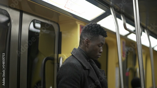 Young black African man wearing covid-19 face mask while commuting metro subway