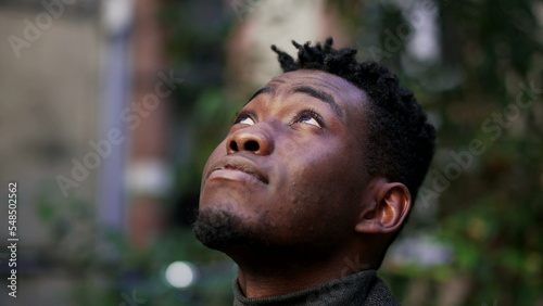 Young black African man looking up at the sky with HOPE and FAITH