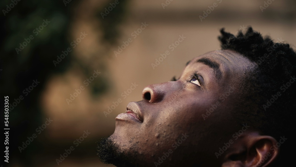 Thoughtful black man face looking at sky smiling Thoughtful black man face looking at sky smiling