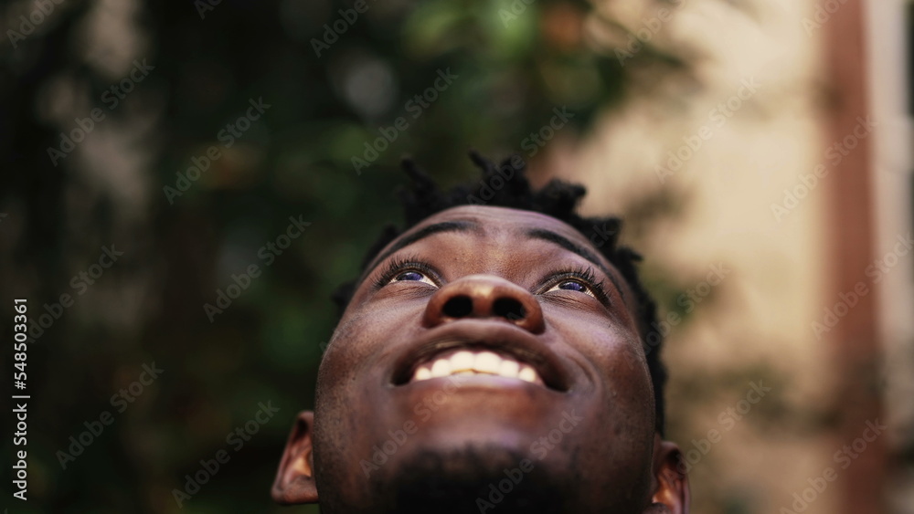 Thoughtful black man face looking at sky smiling Thoughtful black man face looking at sky smiling