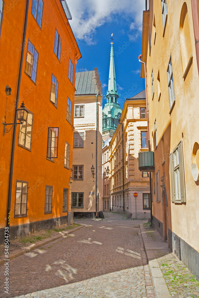 Sweden - Stockholm - The view of charming narrow paved streets in old town Gamla Stan with german church (tyska kyrkan) spire in the distance