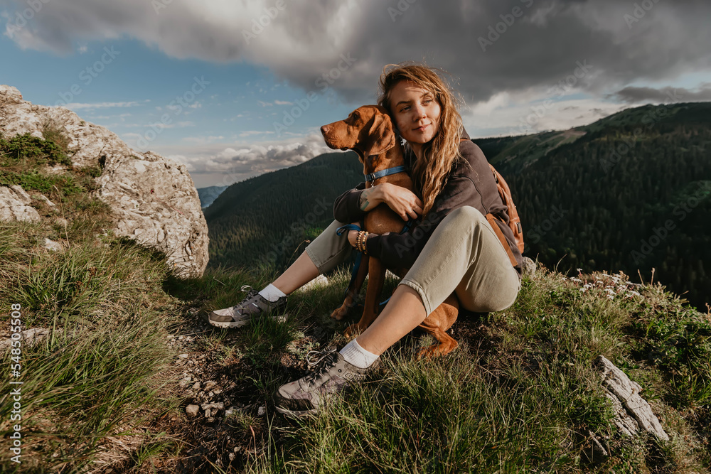 Woman Sitting with Vizsla Dog at Mountain Peak