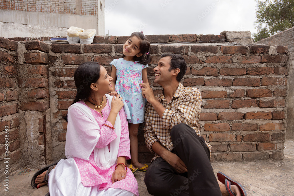 Happy young couple playing with their daughter in backyard Happy young couple playing with their daughter in backyard