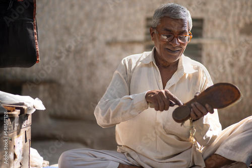 A cobbler repairing shoes on the streets of Delhi photo